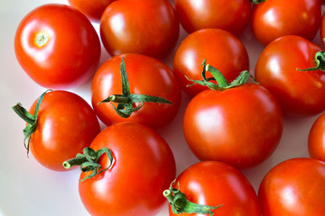 Small red cherry tomatoes on a plate in a group