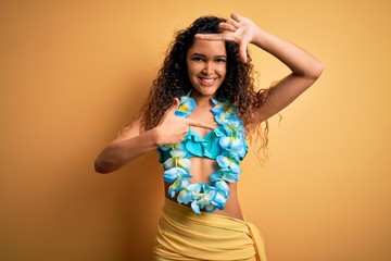 Young beautiful american woman on vacation wearing bikini and hawaiian lei flowers smiling making frame with hands and fingers with happy face. Creativity and photography concept.