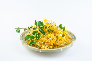 Golden wild honeysuckle in a bamboo sieve on white background