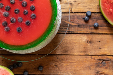 Torte als Melone auf einem Tisch aus Holz mit Götterspeise und Creme