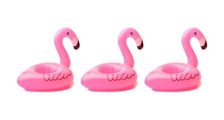 three inflatable small flamingos on an isolated white background. Coasters for the pool. The concept of summer pastime. Beach summer composition
