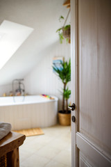 Fototapeta na wymiar Interior of cosy white bathroom at home, door open.