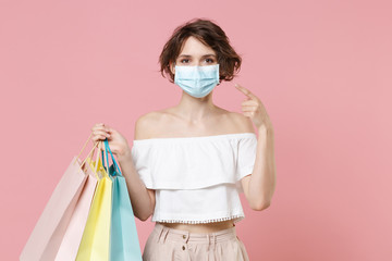 Young woman girl in summer clothes hold package bag with purchases isolated on pink background...