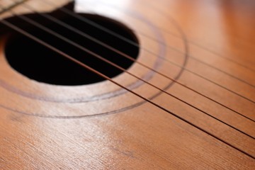 Obraz premium Sound hole of the guitar with the strings for the background.