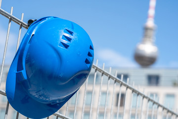Occupational safety and safety gear. Blue hard hat hanging on scaffolding. Focus on foreground. On...