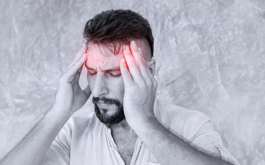 A man suffering headache from a painful head pain  and looking tired, worried and stressful