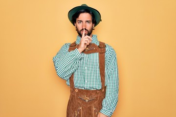 Young handsome man wearing tratidional german octoberfest custome for Germany festival asking to be...