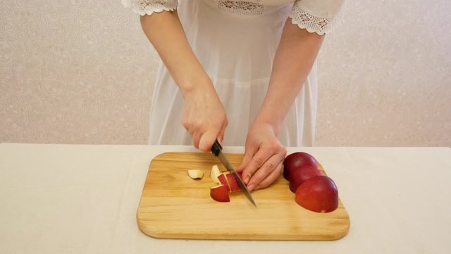 The girl chop the red apple.