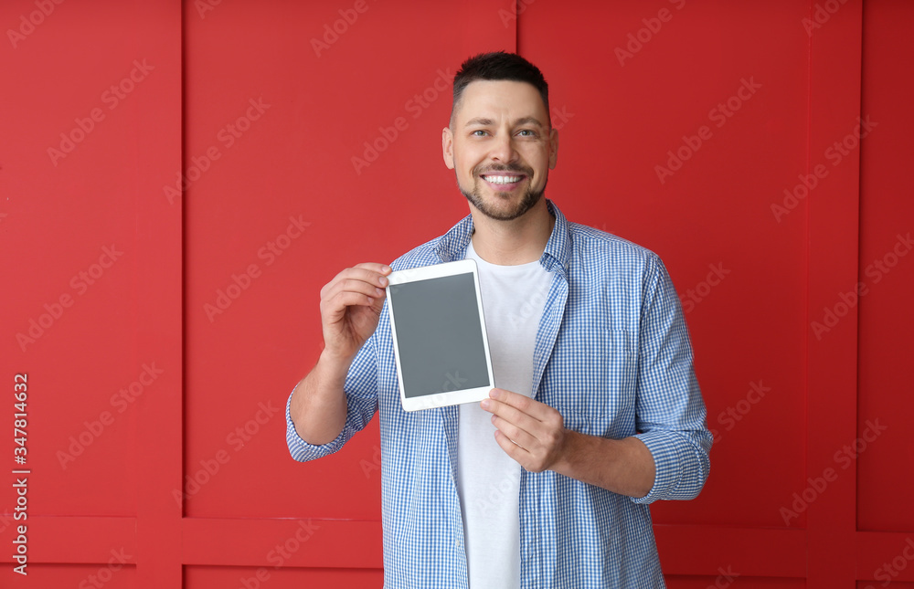 Aufkleber handsome man with tablet computer on color background