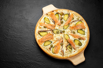 SAN MARINO pizza on a black background, cream-based with mozzarella, Parmesan, salmon, pickle and...
