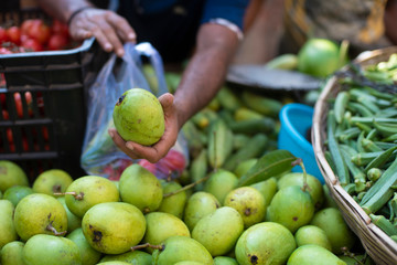A local vegetable vendor showing raw mango in his mobile van during lock down period.