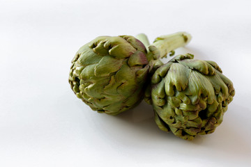 Obraz premium Fresh green Italian Artichoke isolated on white background. Organic local produce vegetable on table top. Vegan diet. Clean eating concept. Close up, top view, flat lay.