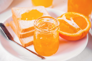 Bread toast with orange jam, glasses of orange juice on the white background. Breakfast concept.