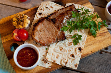 Steak on the bone. Steak on a wooden Board with vegetables and herbs. The view from the top.