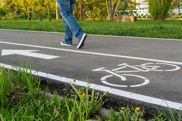 A man walks next to the bike path. Go on wrong path