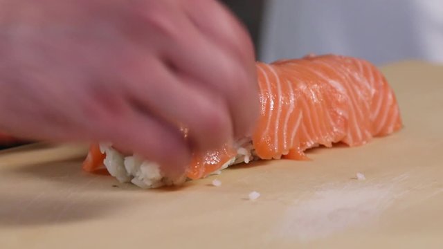 Chef's hands rolling a sushi roll. Sushi making process. Rolls the sushi roll	