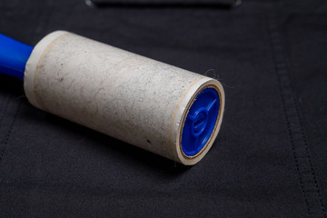 Adhesive roller for cleaning cloth on a black cloth, closeup