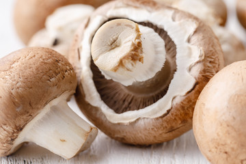 Fresh champignon mushrooms on wooden table, closeup.