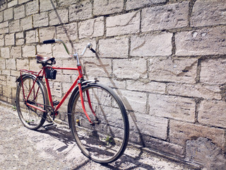 Fototapeta na wymiar Red vintage bicycle near a gray concrete wall