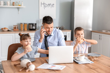 Fototapeta premium Little children keeping father from his work at home