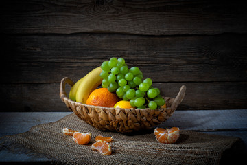 Still life from grape, bananas,orange and flowers