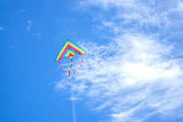 .kite in hand on blue sky in sunny weather and wind. Kite flying in summer