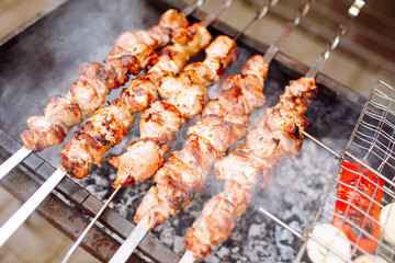 Bbq kebab grilling on open grill, outdoor kitchen. Food festival in city.