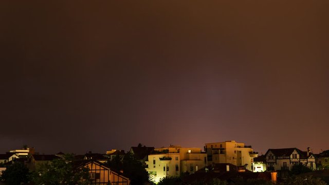 Night thunderstorm time-lapse in Bayonne, France. Stormy weather with rain and lightning bolts.