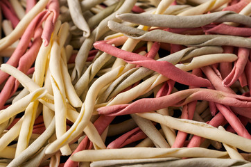 Traditional raw Italian fileja pasta of various colors closeup