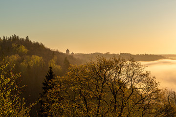 Fototapeta premium A beautiful scene to river Gauja valley and ancient castle Turaida in sunrise at 5 a.m with beutiful fog covering river and surrounding forest, shot was taken in May in Sigulda in Latvia