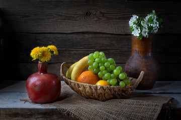 Still life from grape, bananas,orange and flowers