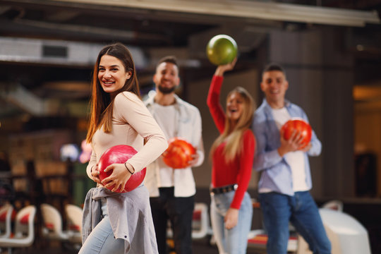 Beautiful Group Of Young People Posing In A Bowling Alley With A Ball In Their Hand