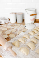 Raw uncooked homemade dumplings with potatoes and onions on wooden table in the kitchen.