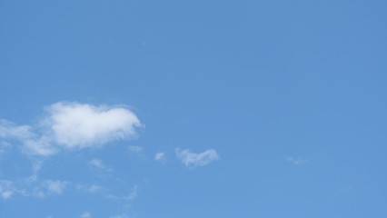 There are only a few white clouds in the clear bright blue sky