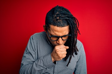 Young handsome african american man with dreadlocks wearing casual shirt and glasses feeling unwell and coughing as symptom for cold or bronchitis. Health care concept.