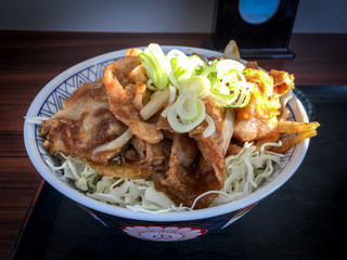 The image of Pork Shogayaki on the rice (as Donburi style) in local restaurant in Japan. Shogayaki is a dish in Japanese cuisine. Shoga  means ginger, and yaki means grill or fry.