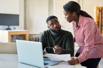 Obraz premium Young African American couple doing some online banking at home