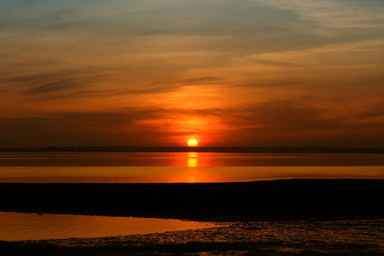 Beautiful Red Sunset near the seaside with some clouds