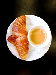 Breakfast with coffee and croissants on table