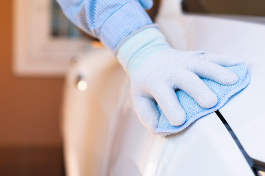 Closeup for man polishing cleaning car with microfiber cloth