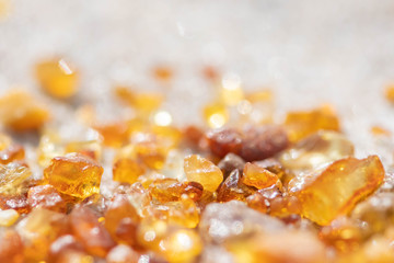 Beautiful pieces of amber on the sandy beach, amber background, close up 