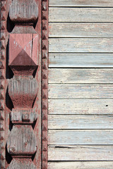 Fragment of the wall of an old wooden building. Wood carving decorates the platband of an old window close-up. Part of the wall of the house from painted boards.