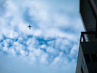 Obraz premium 都会を低く飛ぶ旅客機