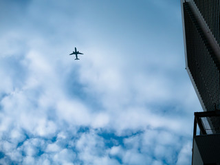 Fototapeta na wymiar 都会を低く飛ぶ旅客機