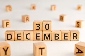 December 30 - from wooden blocks with letters, important date concept, white background random letters around