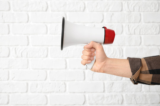Male hand with megaphone on white background
