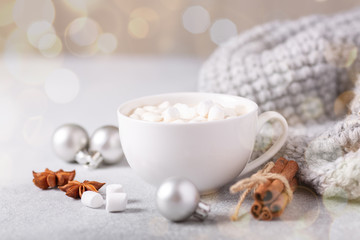 White cup with coffee and marshmallow, sweater, cinnamon. Cozy christmas composition. Hygge concept Soft focus