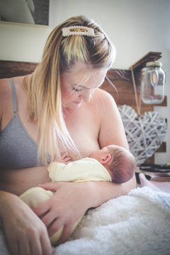 Close up lifestyle image of a mother breastfeeding here new born baby at home after the hospital