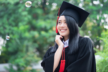 happy smiling college student graduating looking up; concept of successful education, happy...