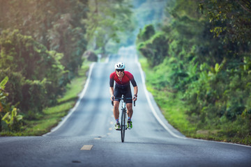 Cycling competition, cyclist athletes riding a race at high speed on mountain road, Sportsmen bikes in the morning,